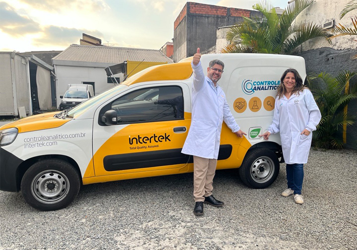 Two Intertek colleagues stand in front of one of our biofuel-powered vans. 
