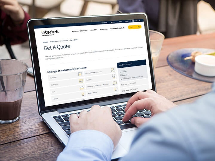 Close-up of adult male using laptop computer at the outdoor cafe looking at Intertek's Performance Gateway tool