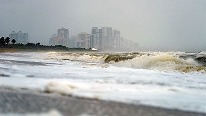 USA, Florida, Naples, Vanderbilt Beach, waves and spray after hurricane Harvey in front of hotel buildings