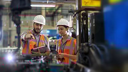Senior Industrial engineer explaining the Robotic arms Welding unit functioning to new engineer. Car auto part manufacturing industry. Production quality control process. Maintenance of manufacturing equipment.